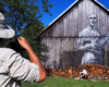 Arkadiusz Andrejkow malujący Tadeusza Góra na starej stodole przy drodze prowadzącej na szybowisko w Bezmiechowej - to najbardziej znany artysta w Bieszczadach młodego pokolenia wykonujący prace zwane deskalami.